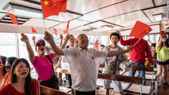 中国国旗を振る中国政府支持派の人々＝香港