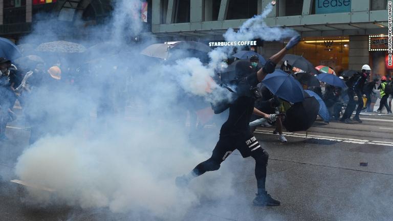 催涙ガスの缶を投げ返すデモ参加者＝１０月６日/Mohd Rasfan/AFP/Getty Images