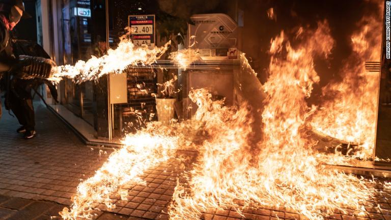 中国建設銀行の店舗に火を放つデモ参加者＝１０月４日/Anthony Kwan/Getty Images