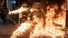 中国建設銀行の店舗に火を放つデモ参加者＝１０月４日