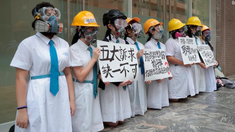 マスクとヘルメットで「五大要求」を求める学生ら/AP