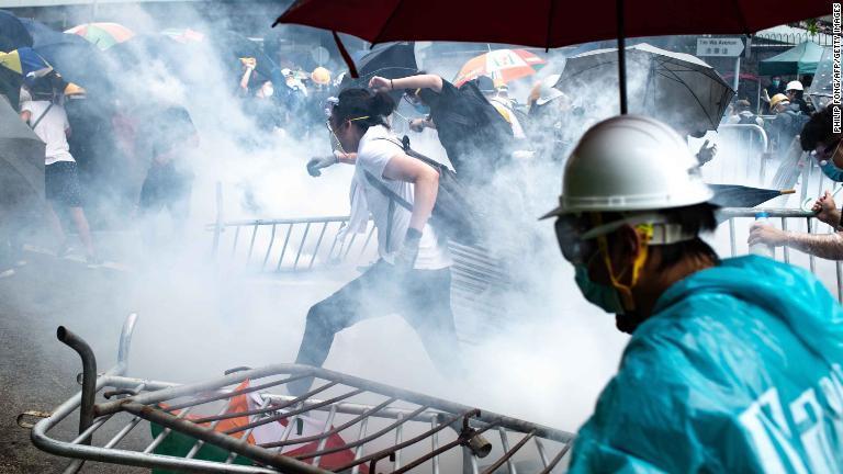 催涙ガスから逃げ出すデモ参加者＝６月１２日/Philip Fong/AFP/Getty Images