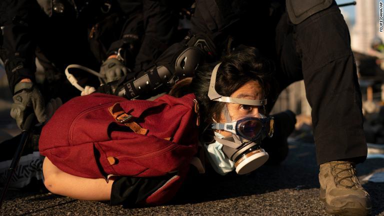 デモ参加者を拘束する警察＝１０月１日/Felipe Dana/AP