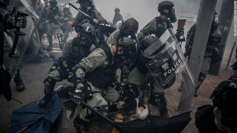 デモ参加者を拘束する警官＝１０月１日、湾仔/Chris McGrath/Getty Images