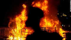 炎の横に立つ反体制派のデモ参加者＝１０月４日