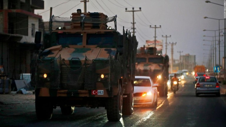 トルコ南部のシリア国境付近の町を通過するトルコ軍の車列/Lefteris Pitarakis/AP