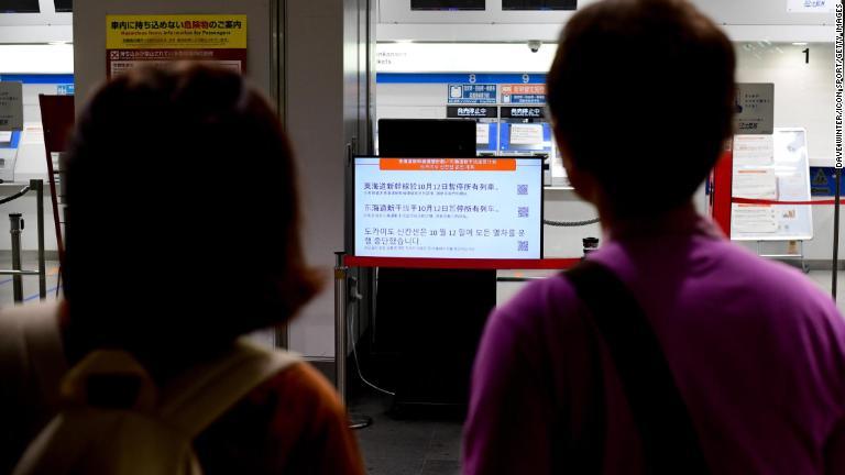 運行状況を確認する人たち＝１２日、横浜/Dave Winter/Icon Sport/Getty Images