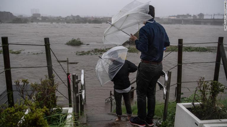 多摩川の様子を眺める人たち＝１２日/Carl Court/Getty Images