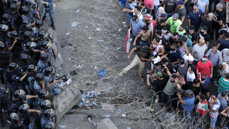 有刺鉄線を取り除き、庁舎に迫ろうとする反政府グループ＝１９日/Hassan Ammar/AP