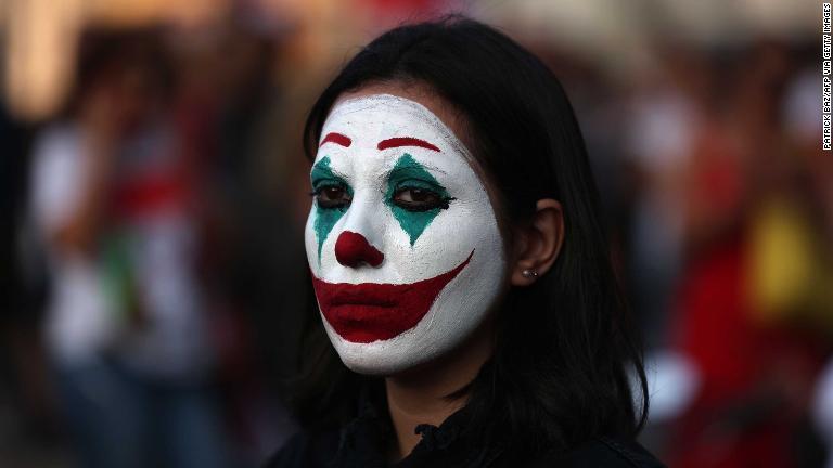 人気コミックの悪役「ジョーカー」に似せて顔に絵を描いたデモ参加者＝１９日、ベイルート/PATRICK BAZ/AFP via Getty Images
