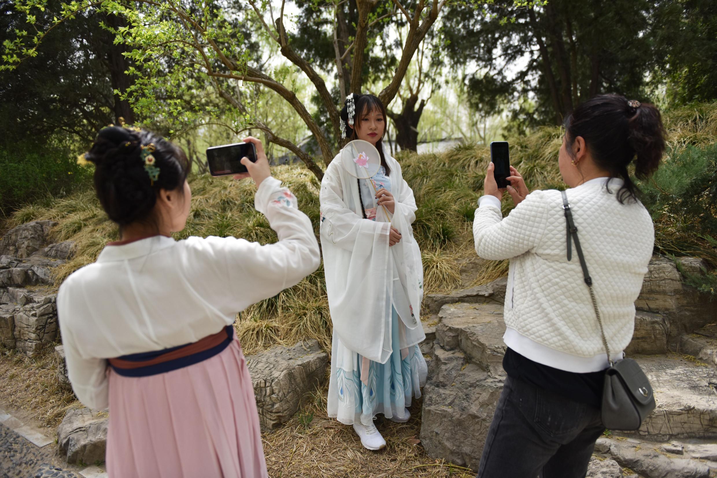 写真撮影のポーズを取る漢服ファン/GREG BAKER/AFP/AFP/Getty Images