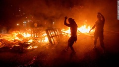 木材などを燃やすデモ参加者たち＝１７日