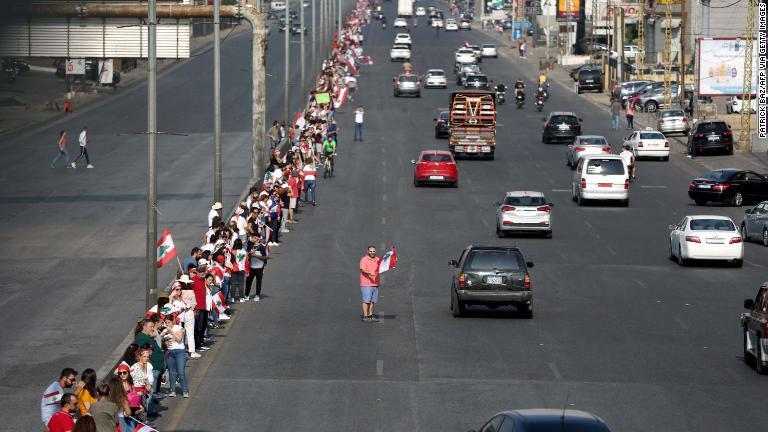 幹線道路で手をつなぎ、デモに参加する反政府グループ＝２７日/Patrick Baz/AFP via Getty Images