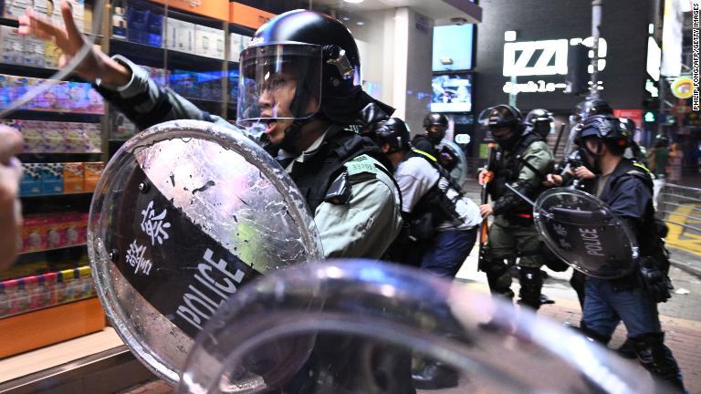 傍観者らに呼び掛ける警官＝１０日、香港/Philip Fong/AFP/Getty Images