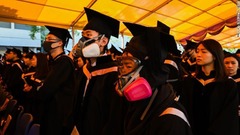 卒業式でガスマスクをする学生ら＝７日、香港