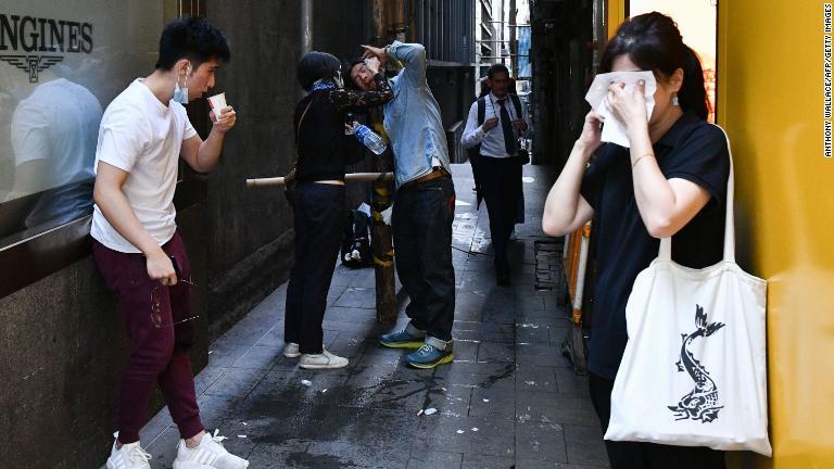 抗議デモ中に警察による催涙スプレーを浴びた人々＝１１日、香港/Anthony Wallace/AFP/Getty Images