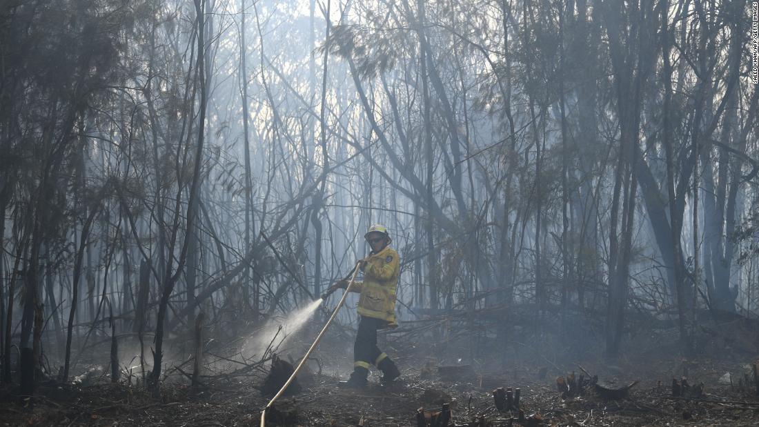 放水を行う消防隊員=12日、シドニーの住宅エリア/SAEED KHAN/AFP/Getty Images