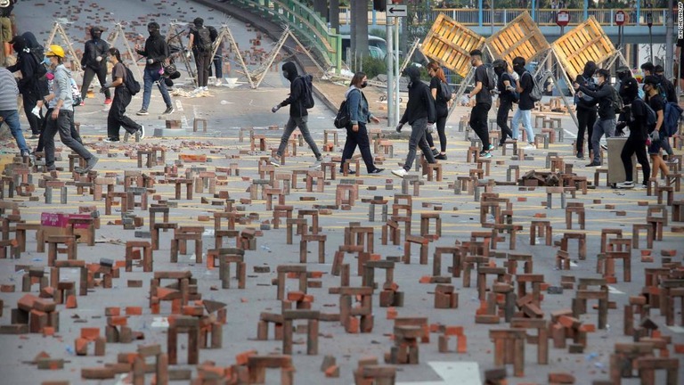 デモ参加者らは、れんがを使ってバリケードを張った＝１４日、香港/Kin Cheung/AP