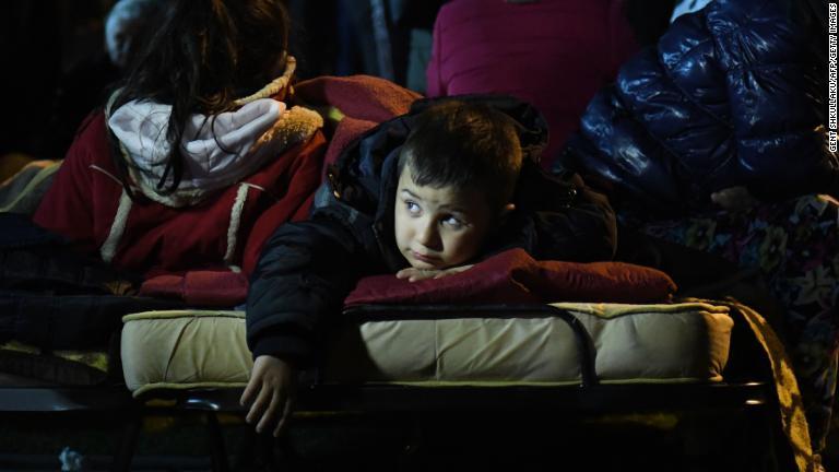 サッカースタジアムに設置された簡易ベッドで横になる少年＝ドゥラス/Gent Shkullaku/AFP/Getty Images
