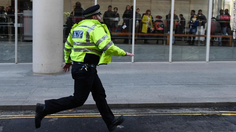 発砲があったとの通報を受け走る警察/Chris J Ratcliffe/Getty Images