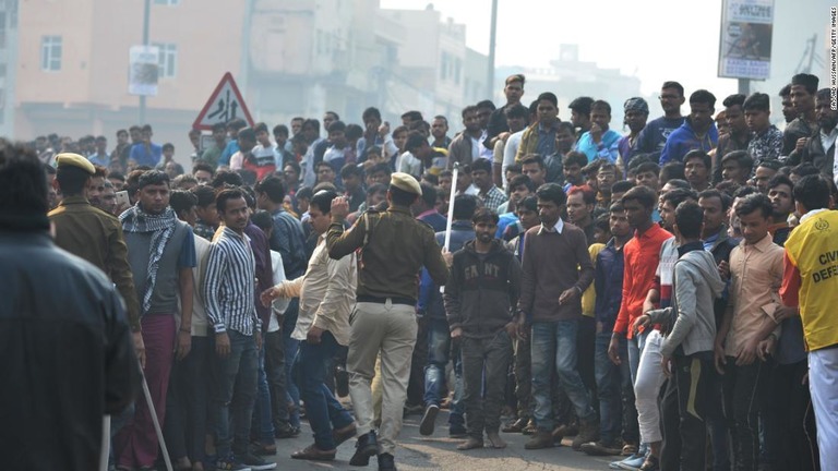 現場付近に集まった人々。警察が道を空けようとしている/Sajjad Hussain/AFP/Getty Images  