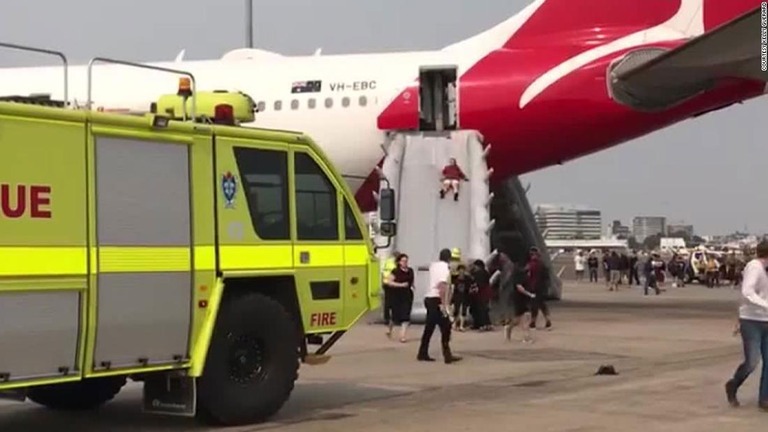 乗客が緊急脱出スライドで降機する様子＝１４日、シドニー空港/Courtesy Kelly Guerard