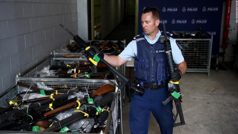 回収された銃器を手にする警察関係者/Phil Walter/Getty Images