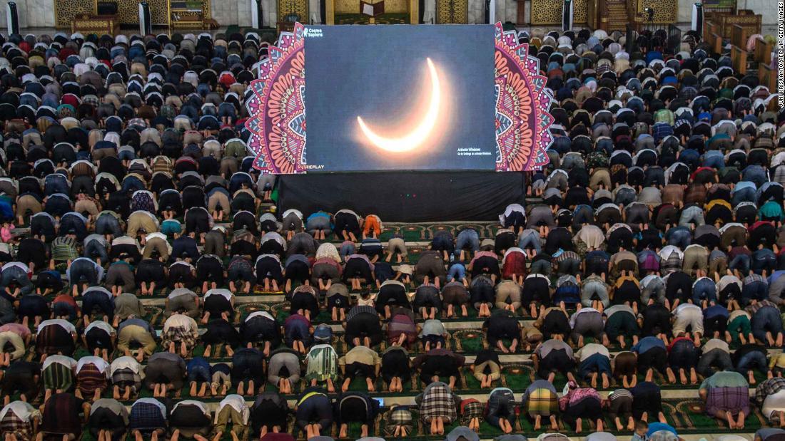 スクリーンの金環日食に祈る人々＝インドネシア/Juni Kriswanto/AFP via Getty Images
