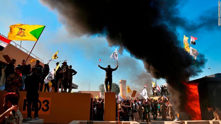 大使館の入り口付近で火を放つデモ隊/Khalid Mohammed/AP