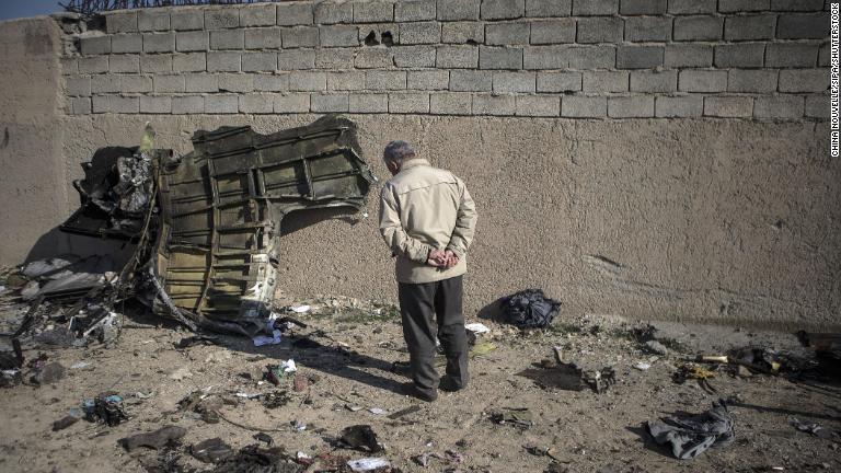 墜落機の破片を見つめる男性/Chine Nouvelle/SIPA/Shutterstock