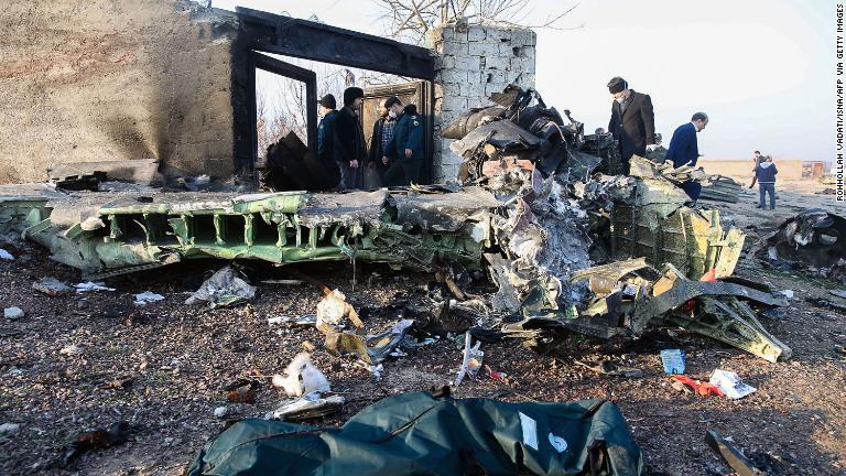 残骸の近くに立つ人々/Rohhollah Vadati/ISNA/AFP via Getty Images