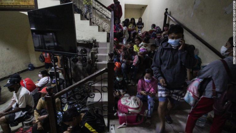 避難先の階段で休む村人たち/Dante Diosina Jr/Anadolu Agency via Getty Images