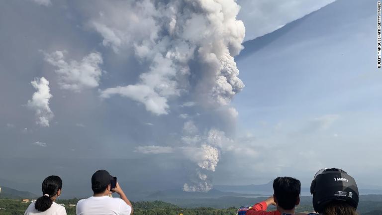 噴火の様子を写真に収める人々/Bullit Marquez/AFP/Getty Images