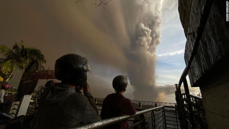煙や灰が立ち上るのを眺める人々/Aaron Favila/AP