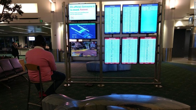 空港のモニターでゲームをプレーする男性/courtesy Stefan Dietz/@coyotetrips