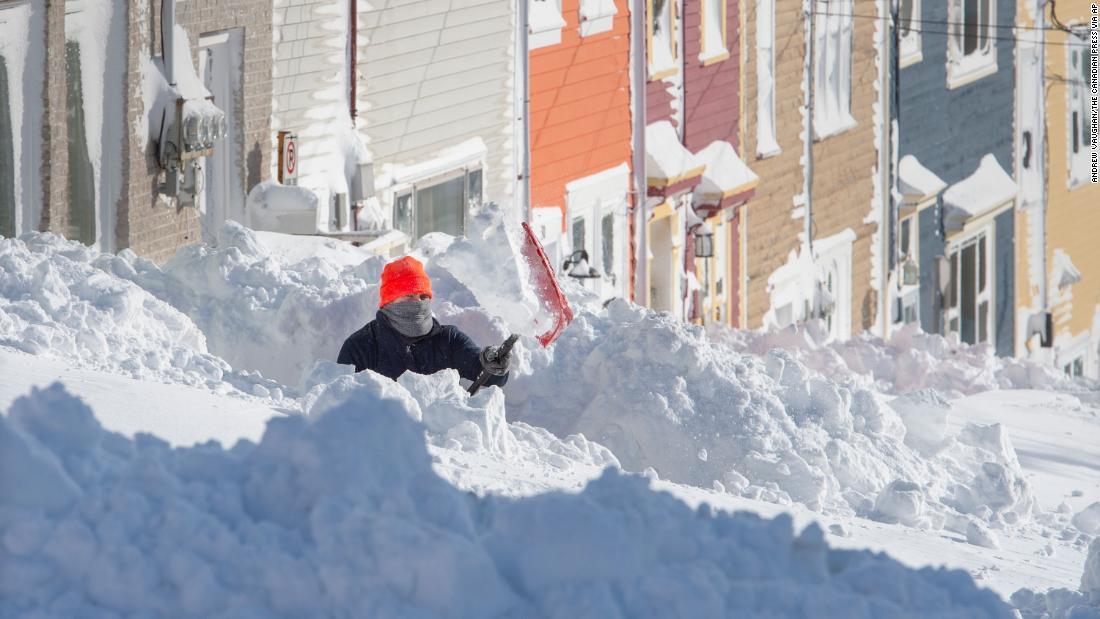歩道の雪かきをする男性=18日、セントジョンズ市/Andrew Vaughan/The Canadian Press via AP