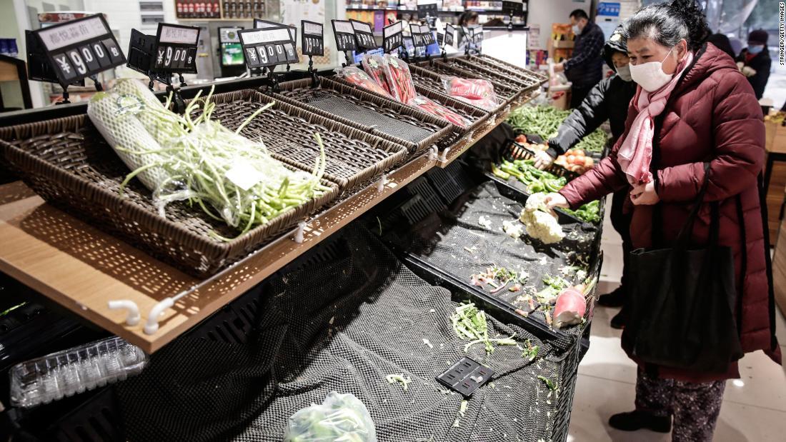 武漢市の食料品店で野菜を買う客もマスクを着用/Stringer/Getty Images