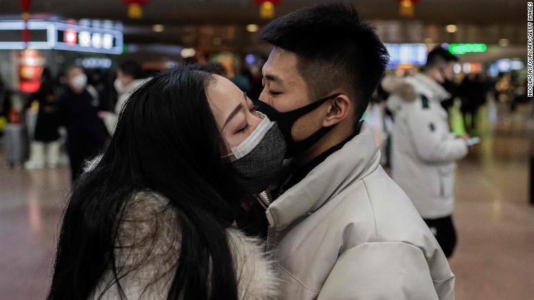 マスク越しに別れのキスをするカップル＝北京市/Nicolas Asfouri/AFP/Getty Images
