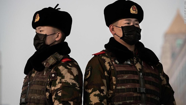 新型コロナウイルスの感染を防ぐためマスクを着用する地元警官ら＝２７日、北京駅/NICOLAS ASFOURI/AFP/Getty Images