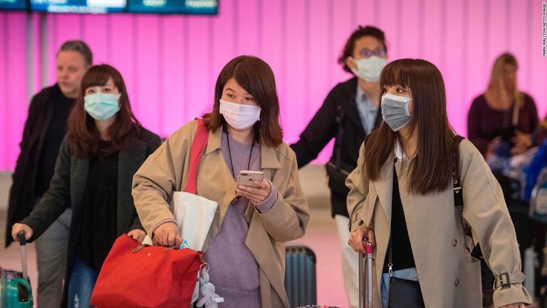 マスクを着用して到着した乗客ら＝２２日、米ロサンゼルス国際空港/Mark Ralston/Getty Images