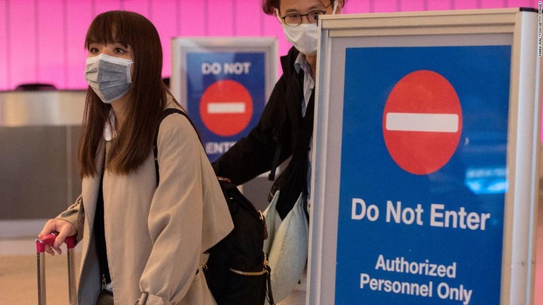 ロサンゼルス国際空港でマスクを着用する搭乗客＝１月２２日/Mark Ralston/Getty Images