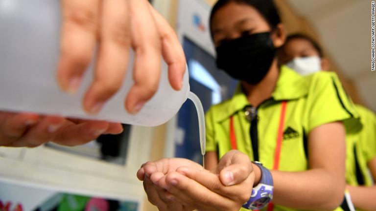 教室に入る際にアルコール消毒を行う学生＝カンボジア・プノンペン/Tang Chhin Sothy/AFP/Getty Images