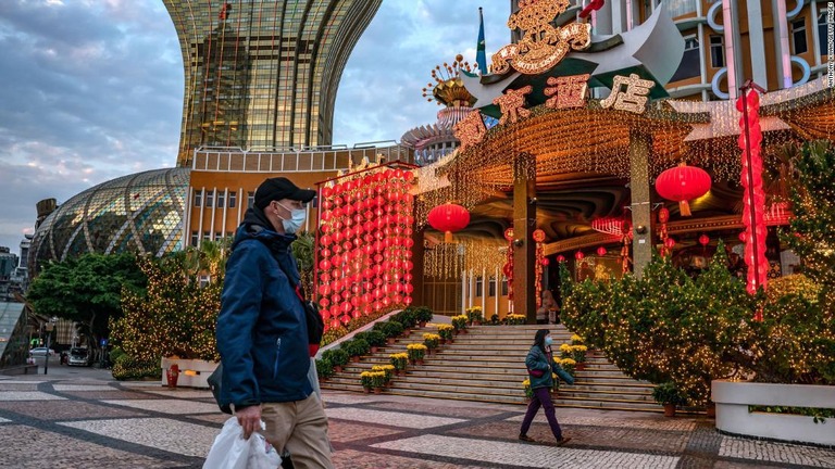 マスクを着用してホテル前を歩く人々＝１月２８日、マカオ市内/Anthony Kwan/Getty Images