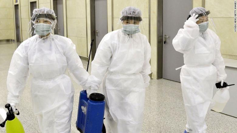 防護服を着用し、平壌国際空港で検疫を行う作業員 Kyodo News/Getty Images