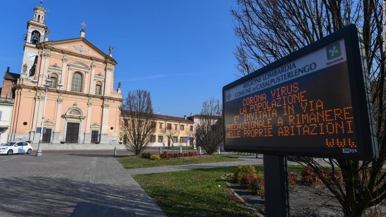 自宅待機を呼び掛ける電光掲示板＝２２日、イタリア・ミラノ/MIGUEL MEDINA/AFP via Getty Images