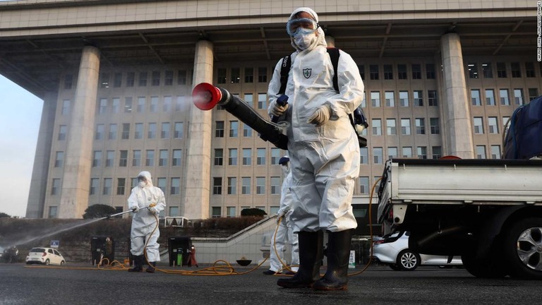 防護服を着用し任務にあたる作業員ら＝２４日、韓国/Chung Sung-Jun/Getty Images