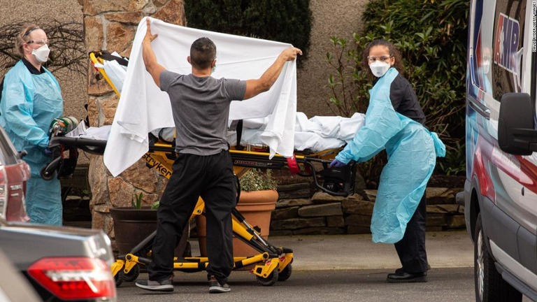 医療関係者が担架に乗せた患者を救急車に運び込む様子＝シアトル郊外の介護施設/David Ryder/Getty Images