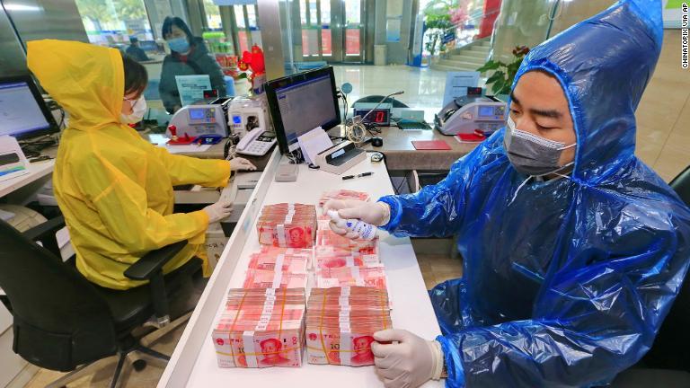 中国四川省の銀行では行員がお札を消毒＝２月２６日/Chinatopix Via AP