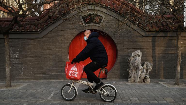 北京でマスク姿でバイクに乗る男性＝２月２３日/Kevin Frayer/Getty Images