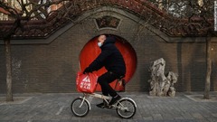 北京でマスク姿でバイクに乗る男性＝２月２３日